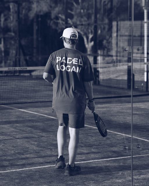 A player walking on court in a Padel Logan shirt